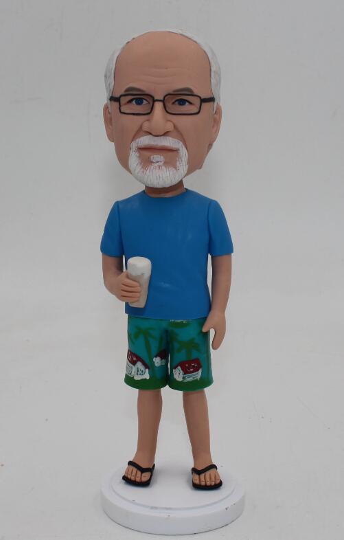 Casual man in blue tshirt and hawaiian shorts with a beer glass in hand bobble head